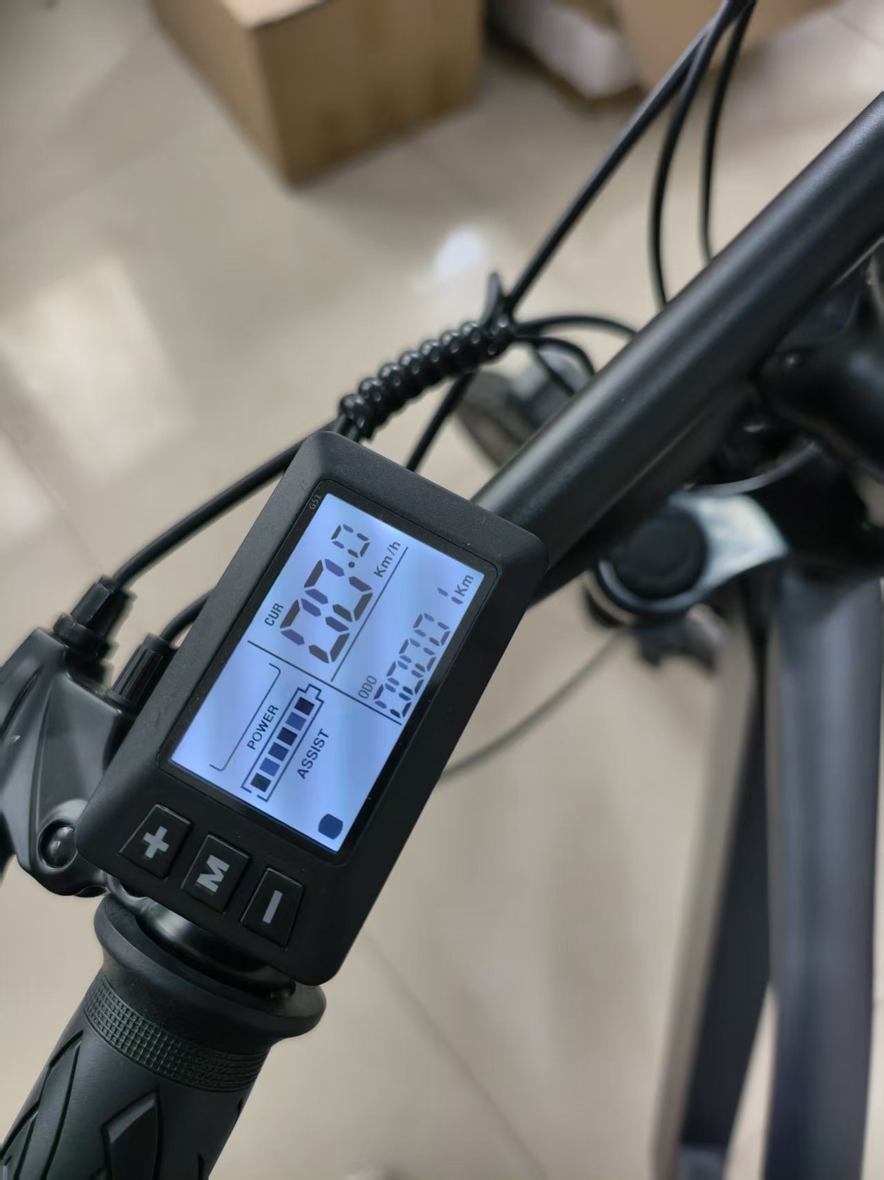 LCD display on a handlebar showing speed, battery and assist level
